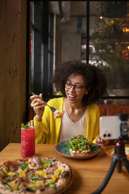 おいしい食べ物を食べるミディアムショットの女性