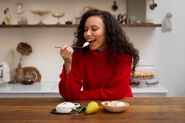 フレッシュチーズを食べるミディアムショットの女性