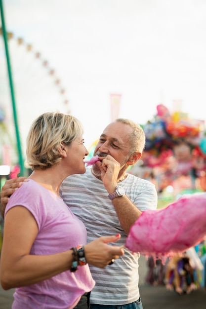 Medium shot woman eating pink cotton candy