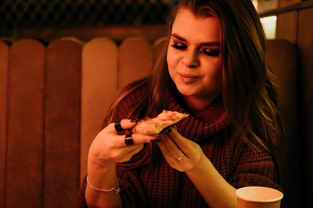 Free photo medium shot woman eating pizza