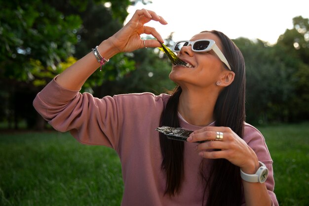 medium shot woman  eating seaweed snack