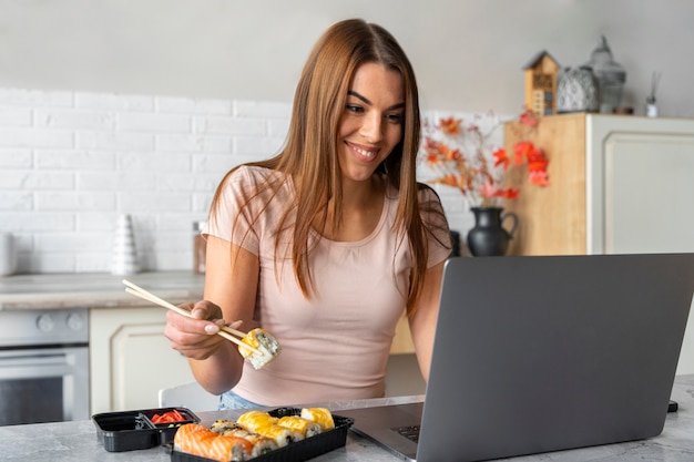 机で寿司を食べるミディアムショットの女性