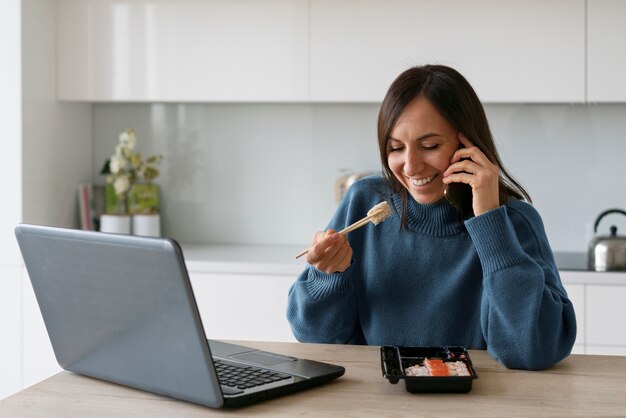Женщина среднего роста ест суши дома