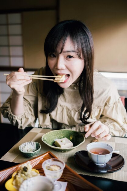 Medium shot woman eating with chopsticks