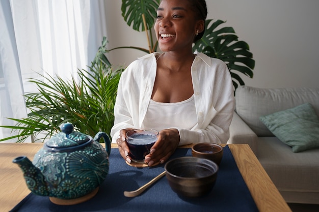 自宅で青抹茶を楽しむミディアムショットの女性