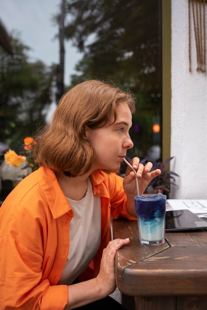 Medium shot woman enjoying a blue matcha