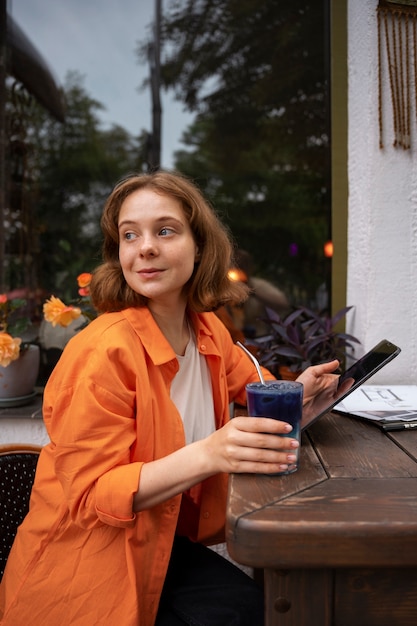 Free photo medium shot woman enjoying a blue matcha