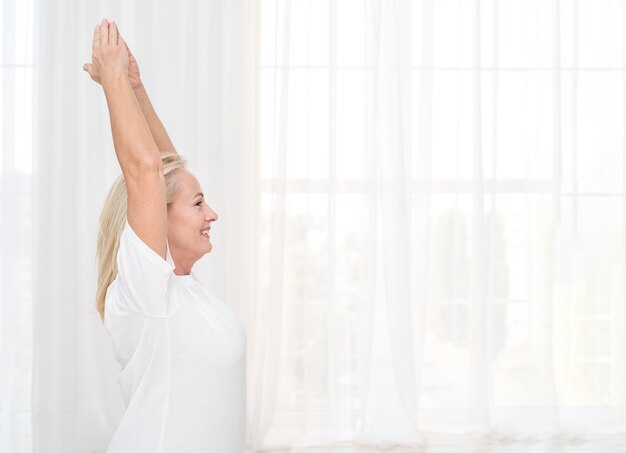 Medium shot woman exercising at home