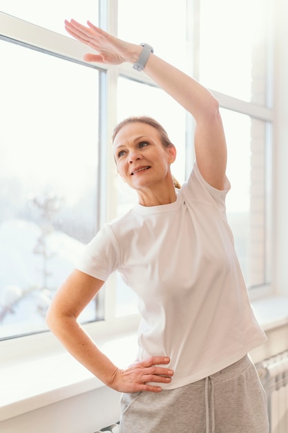 Medium shot woman exercising indoors