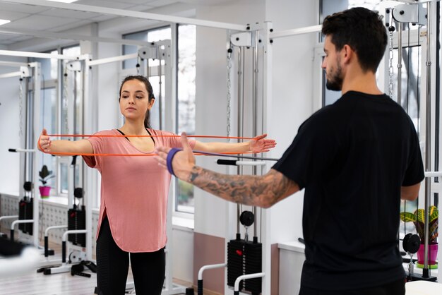 Medium shot woman exercising with band