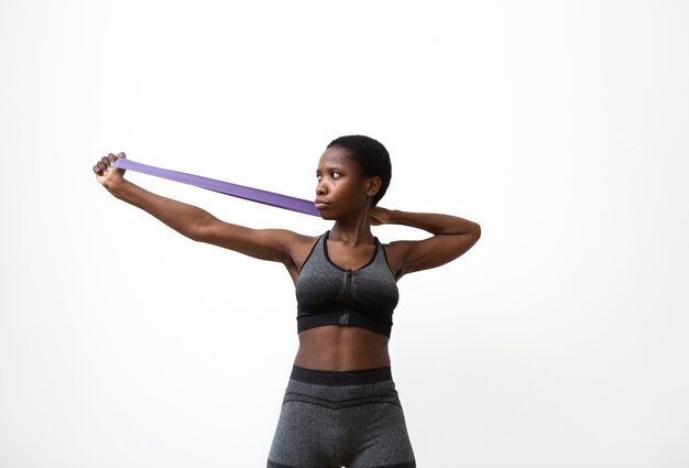 Medium shot woman exercising with elastic band