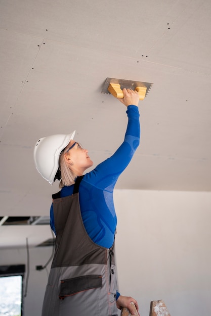 Free photo medium shot woman fixing roof