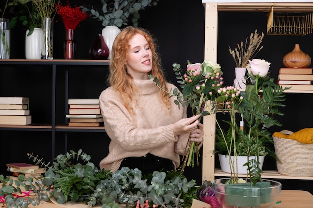 Donna del tiro medio al negozio di fiori