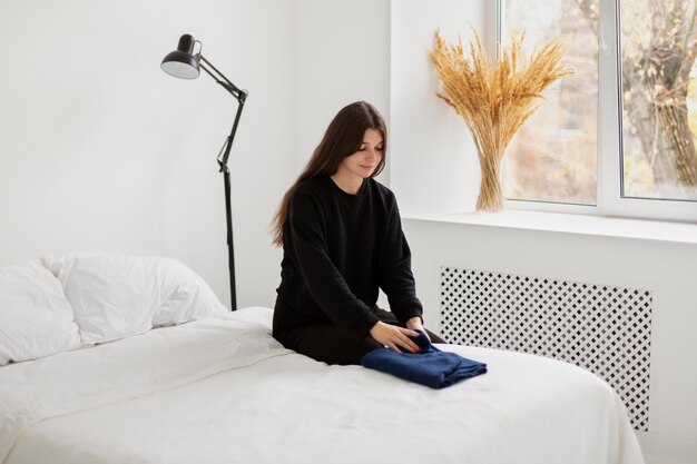 medium shot woman folding clothes