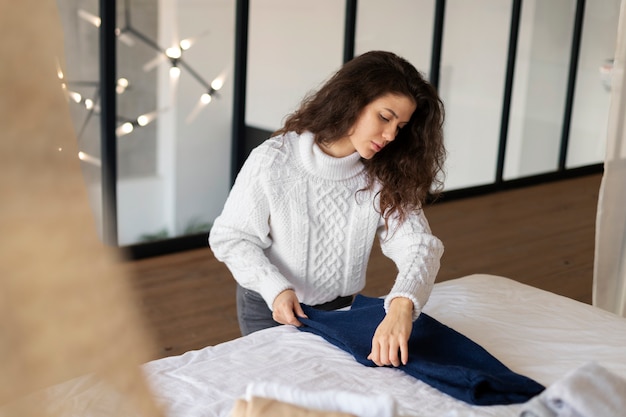 Medium shot woman folding jeans