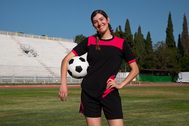 Foto gratuita giocatore di football americano della donna del colpo medio sul campo