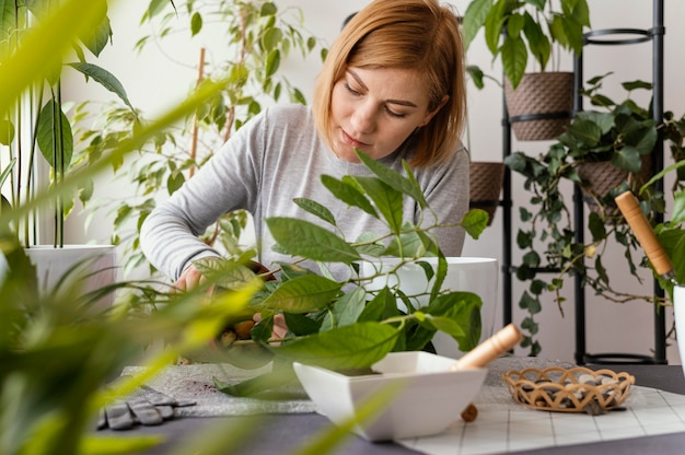 Giardinaggio della donna del colpo medio a casa