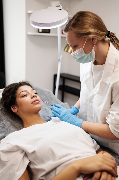 Medium shot woman getting hyaluronic acid injection