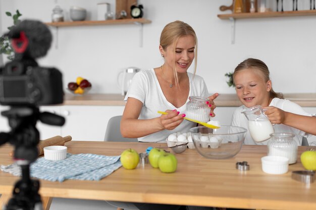 Medium shot woman and girl cooking