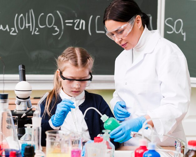 Medium shot woman and girl in lab