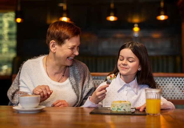 Medium shot woman and girl at table