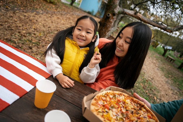 テーブルでミディアムショットの女性と女の子