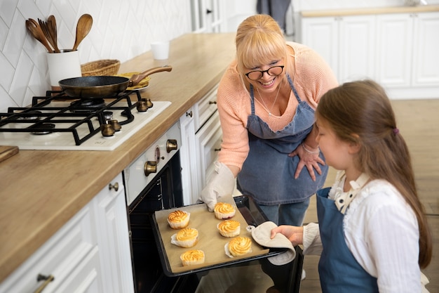 Medium shot woman and girl with pastry