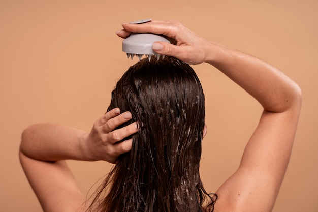 Free photo medium shot woman giving herself scalp massage