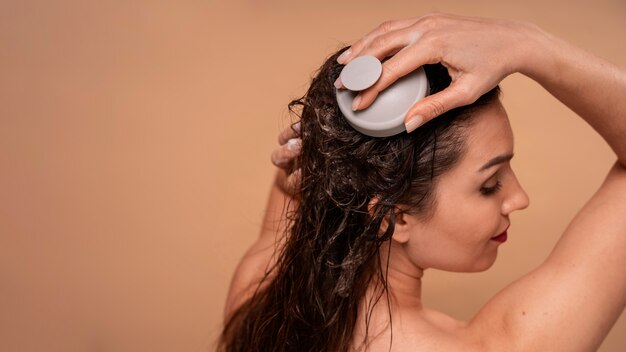Medium shot woman giving herself scalp massage