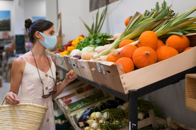 Средний выстрел женщина за продуктами, делая покупки