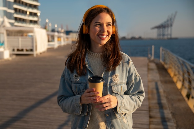 Free photo medium shot woman  hanging out on a jetty