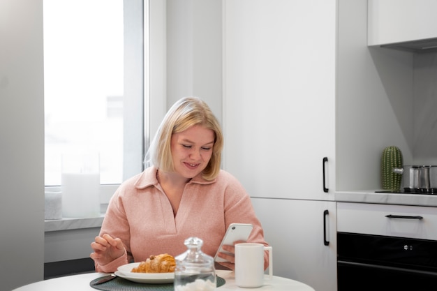 Бесплатное фото Женщина среднего роста завтракает