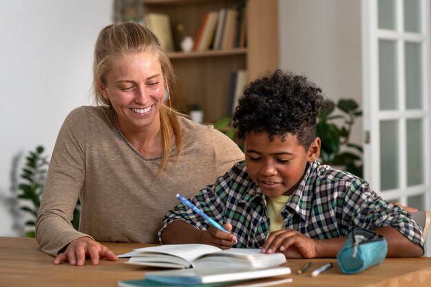 Medium shot woman helping kid with homework