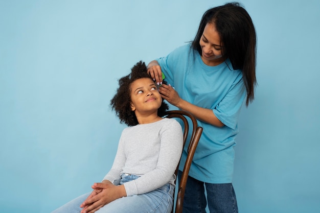 Medium shot woman helping kid with lice