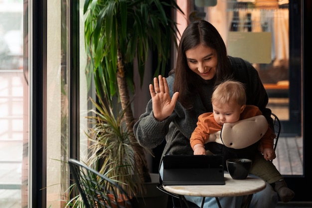 Foto gratuita donna del colpo medio che tiene bambino in marsupio