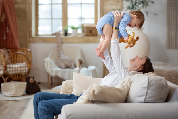 Medium shot woman holding baby up