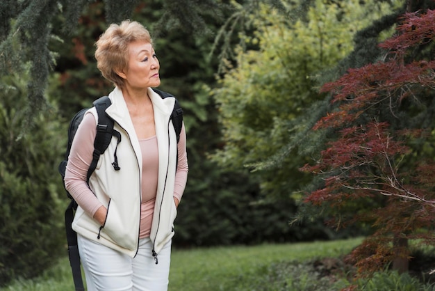 Medium shot woman holding backpack