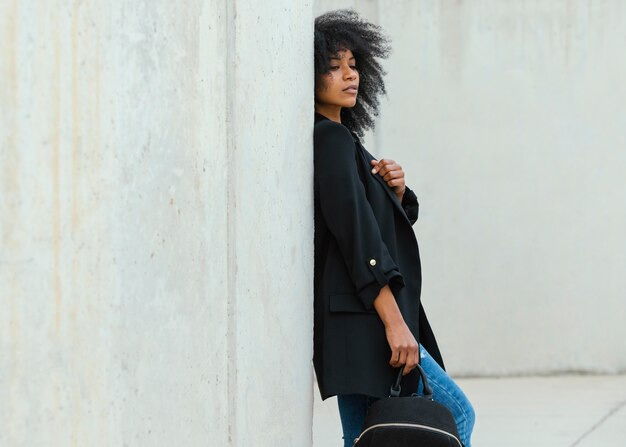 Medium shot woman holding backpack