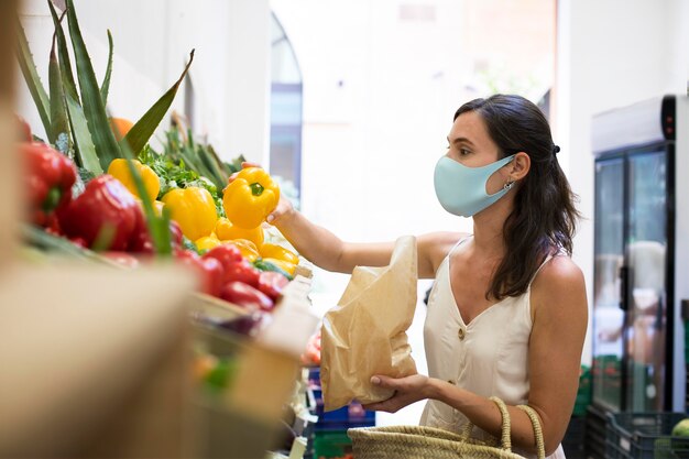 Medium shot woman holding bell pepper