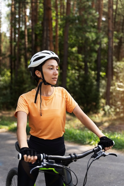 自転車を保持しているミディアムショットの女性