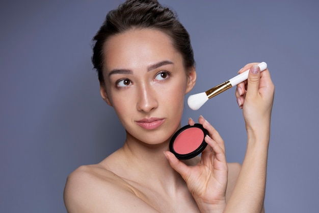 Medium shot woman holding blush