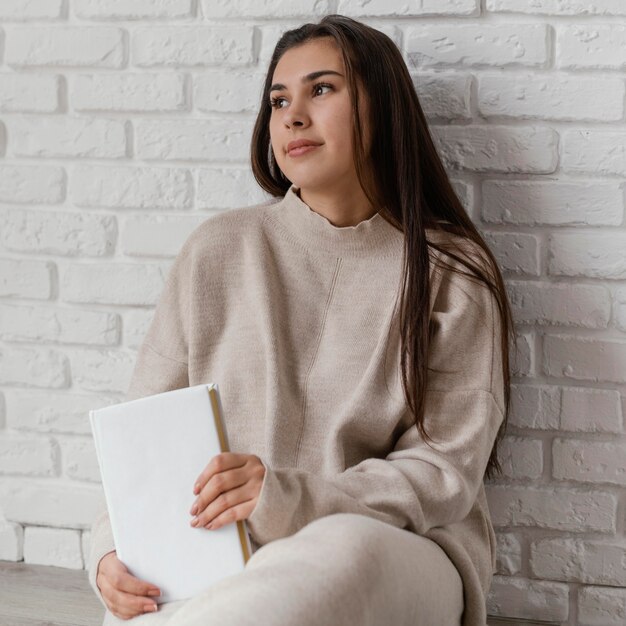 Medium shot woman holding book