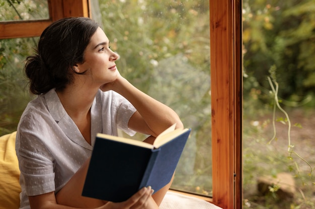 Foto gratuita libro della holding della donna del colpo medio