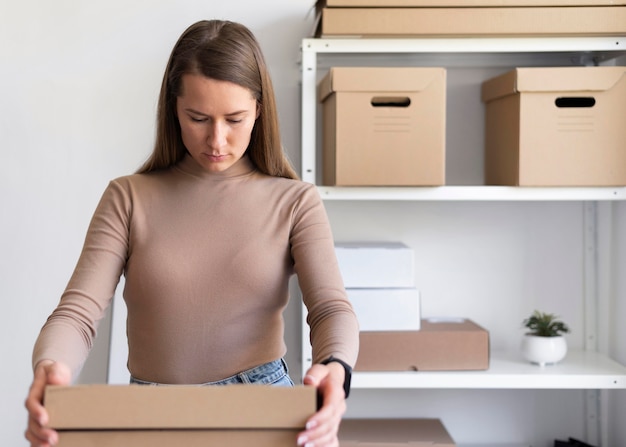 Medium shot woman holding box