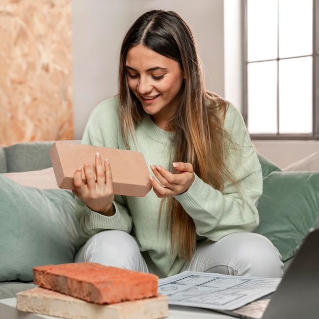 Free photo medium shot woman holding brick