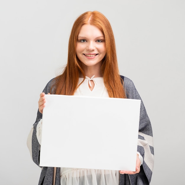 Medium shot woman holding canvas