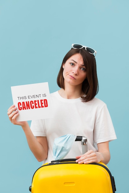 Medium shot woman holding a card with a canceled event message