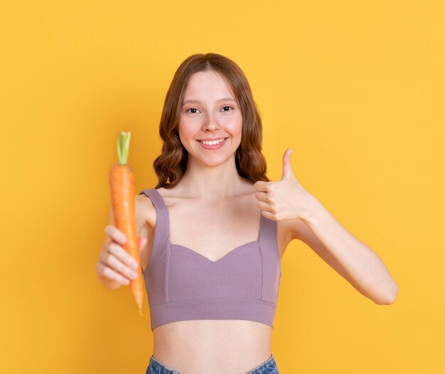 Medium shot woman holding carrot