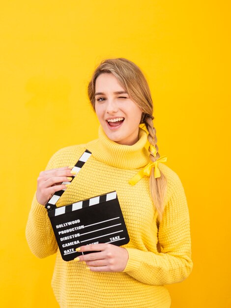 Medium shot woman holding clapboard