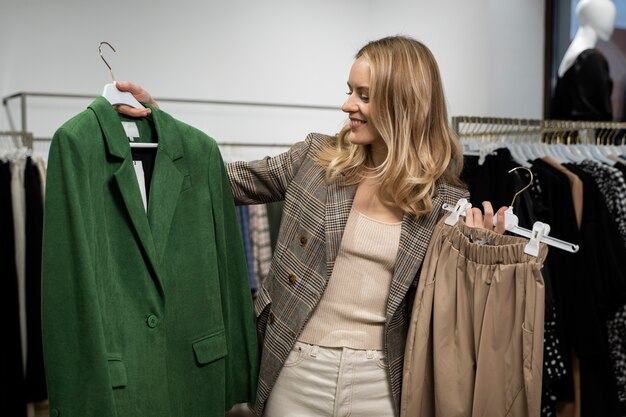 Medium shot woman holding clothing items